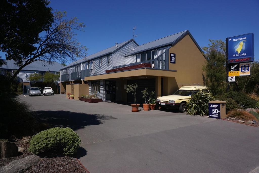 a building with a car parked in front of it at Sherborne Motor Lodge in Christchurch
