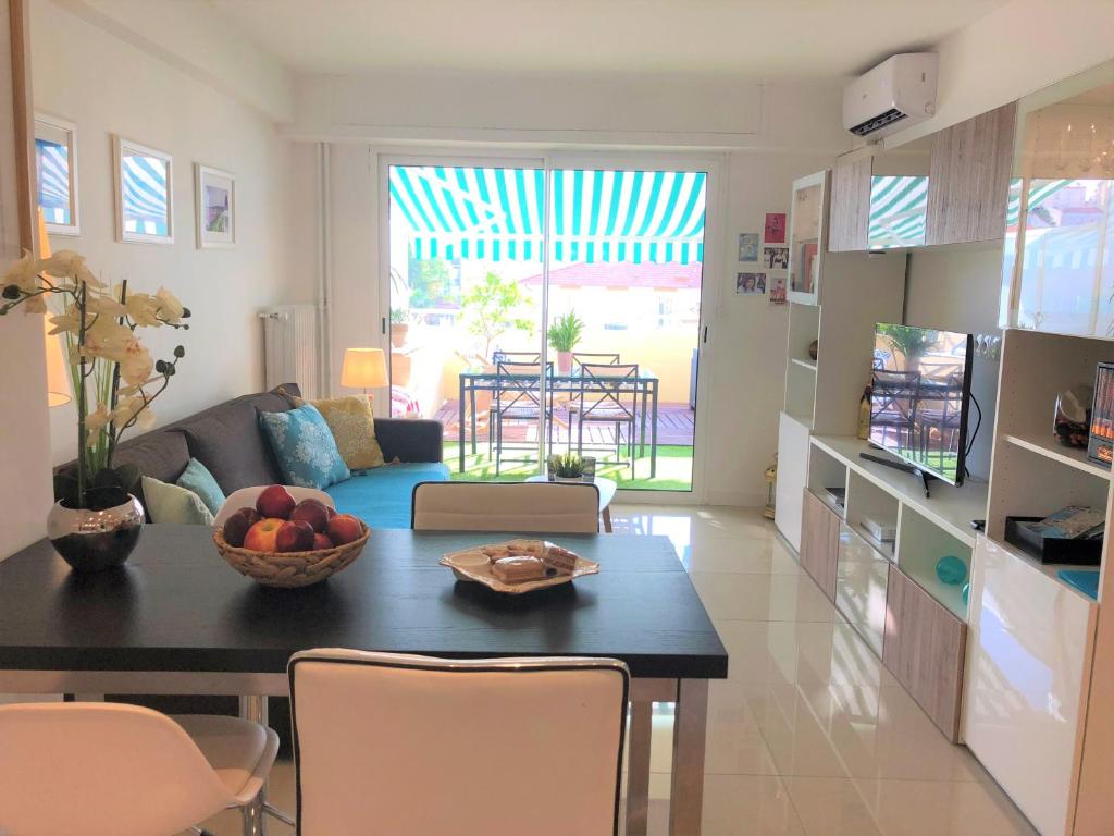 a living room with a table with a bowl of fruit on it at Appartement Cosy Calme Central-Terrasse Proche Palais in Cannes
