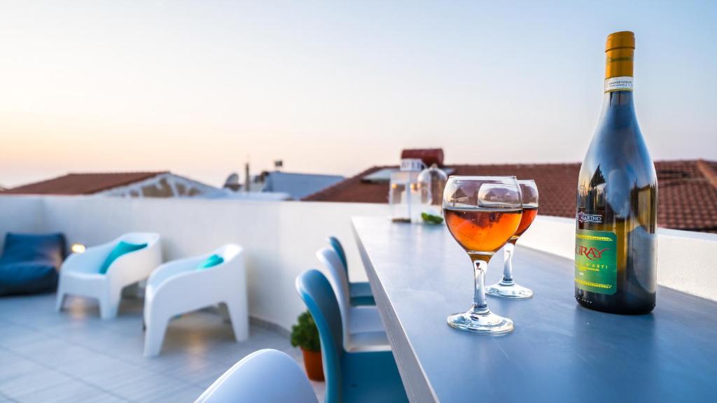 una bottiglia di vino e un bicchiere su un tavolo di Veranda Panormo a Panormos