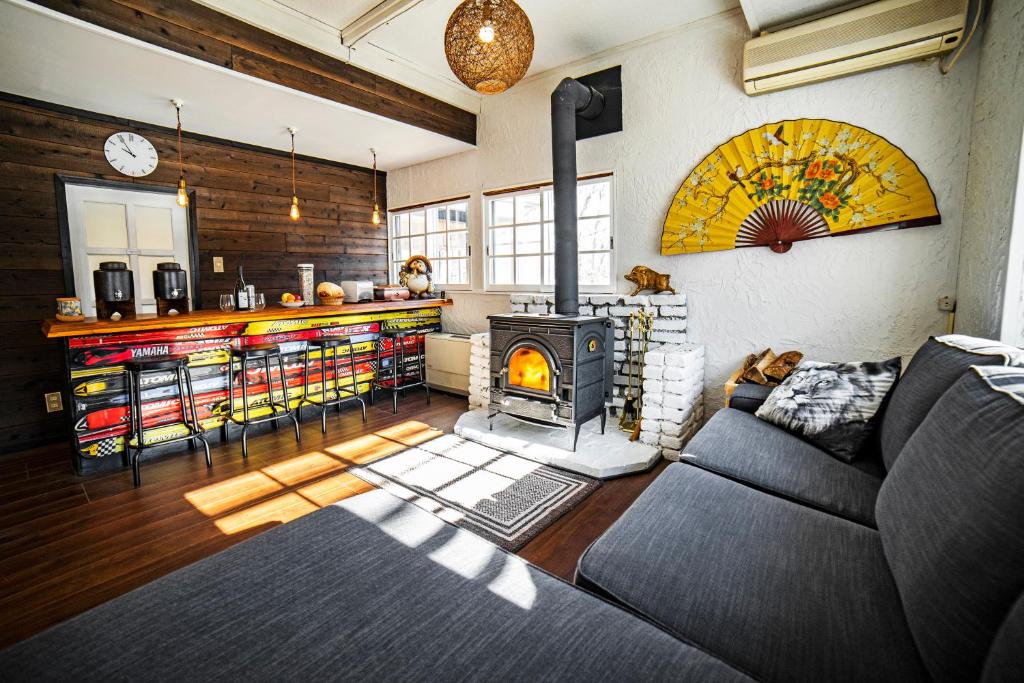 a living room with a couch and a fireplace at Hakuba Matata Lodge in Hakuba