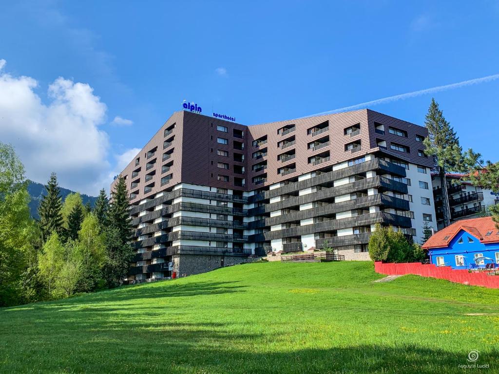 a large building on top of a green field at Apartament Alpin resort etaj 7 in Poiana Brasov
