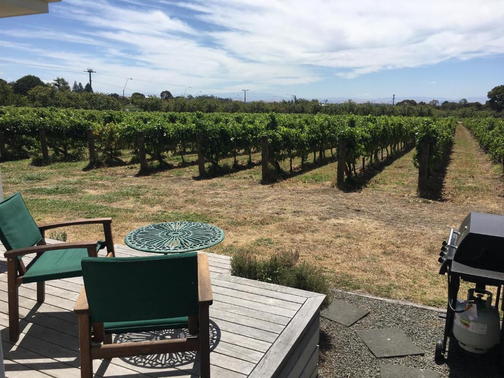 a patio with a table and chairs in a vineyard at Tuki Vineyard Cottage in Havelock North