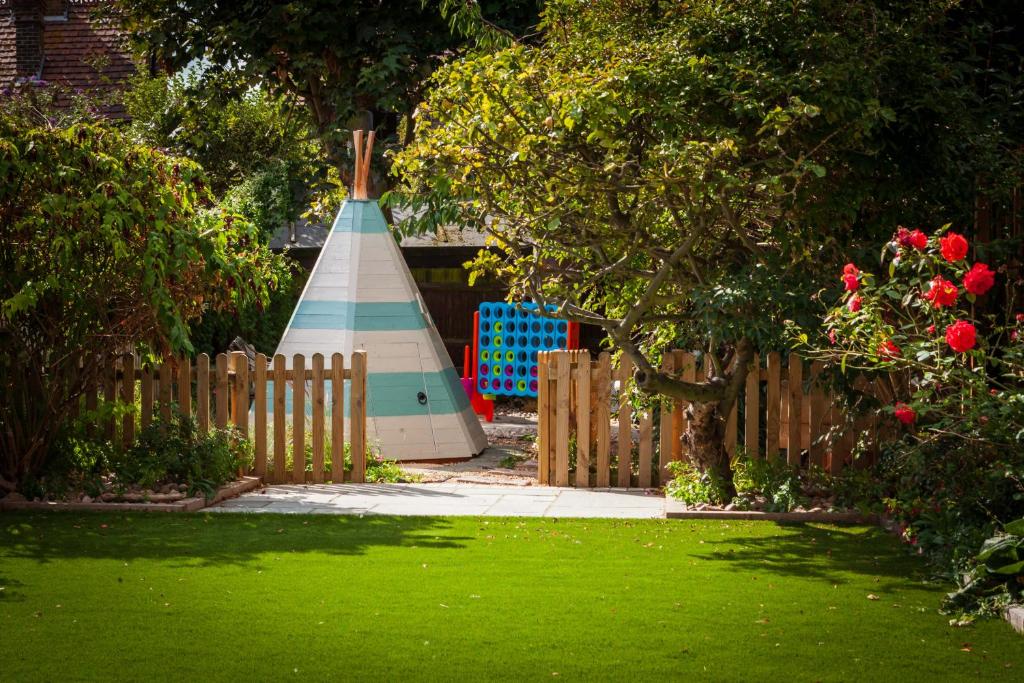 a wooden fence with a yard with a boat behind it at Sea Glimpses with garden, beachhut, parking in Broadstairs