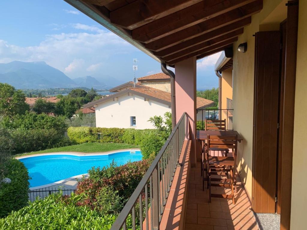 un balcon avec vue sur une piscine dans l'établissement Casa Delisa, à Manerba del Garda