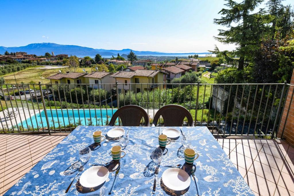 una mesa azul con copas de vino en el balcón en Pegaso, en Polpenazze del Garda