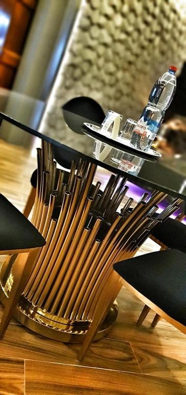 a table with black chairs and a bottle on top at Hotel Ramka & Restaurant & Wine Bar in Poznań