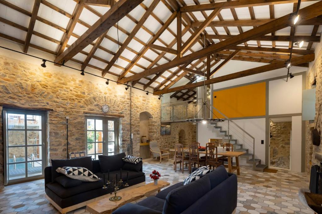 a living room with couches and a dining room at Olive Press 1816 in Riglia