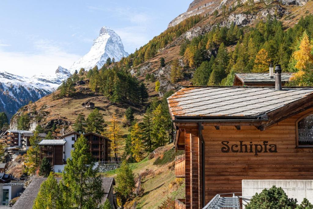 a wooden building with a mountain in the background at Luxury Chalets & Apartments by Mountain Exposure in Zermatt