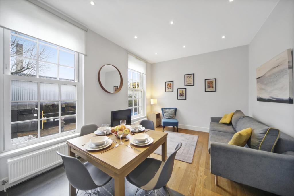 uma sala de estar com uma mesa e um sofá em Executive Apartments in Central London Euston FREE WIFI City Stay Aparts London em Londres