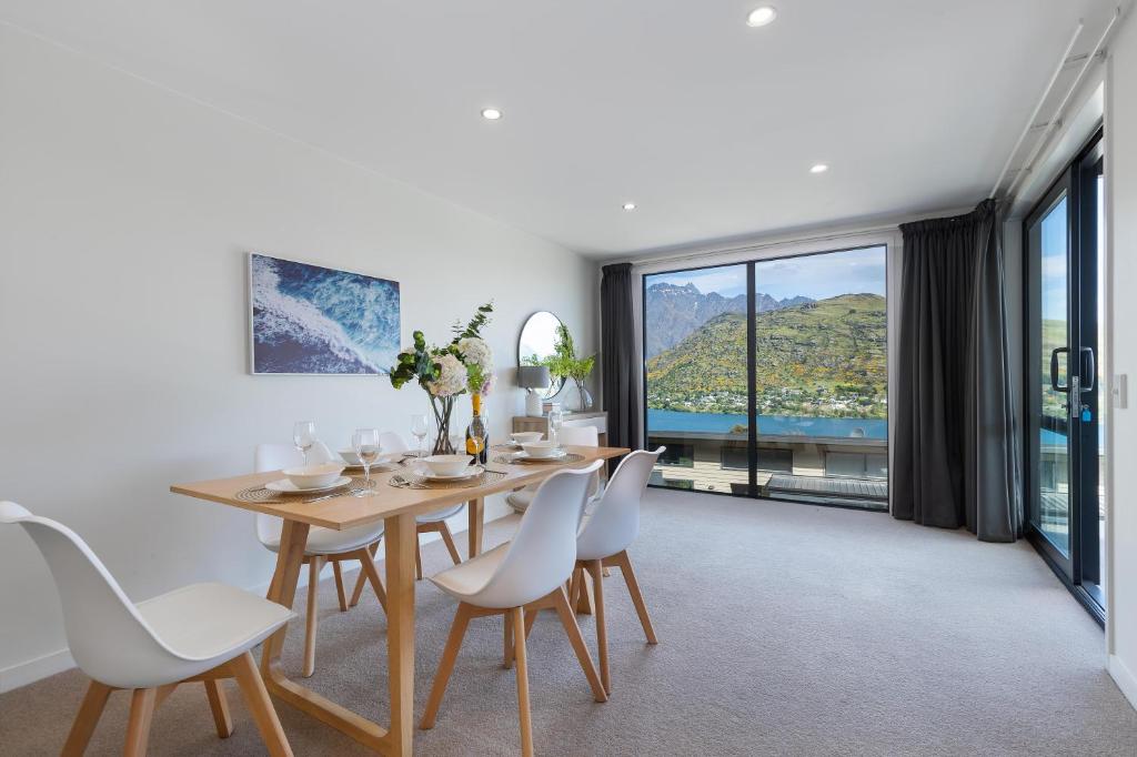 a dining room with a table and chairs and a large window at Alpine Getaway in Queenstown