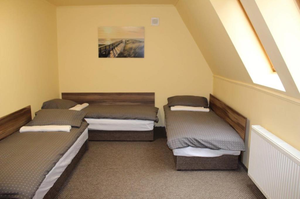 a room with three beds in a room at Chill House in Miskolc