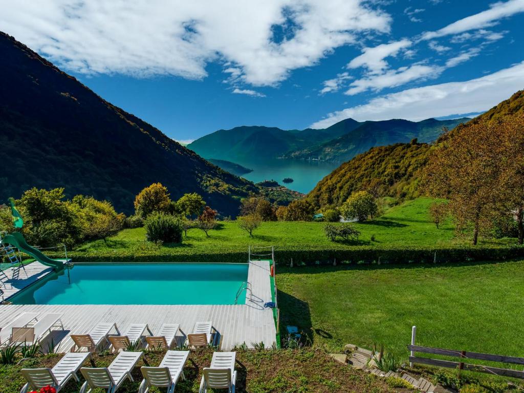 マローネにあるCozy Chalet at Marone Lake Lombardy with Poolの山々を背景に椅子付きのスイミングプール