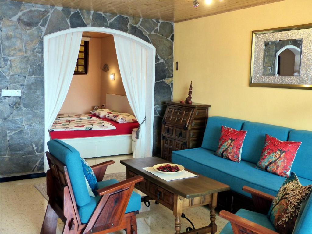 ein Wohnzimmer mit einem blauen Sofa und einem Bett in der Unterkunft Apartment Cueva del Mar in Los Realejos