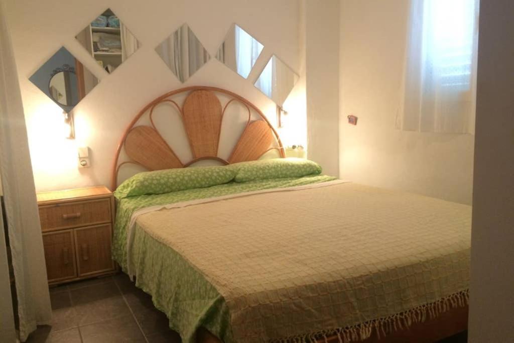 1 dormitorio con 1 cama grande y cabecero de madera en Edificio Es Pujols 10 ALTA TURISTICA, en Es Pujols