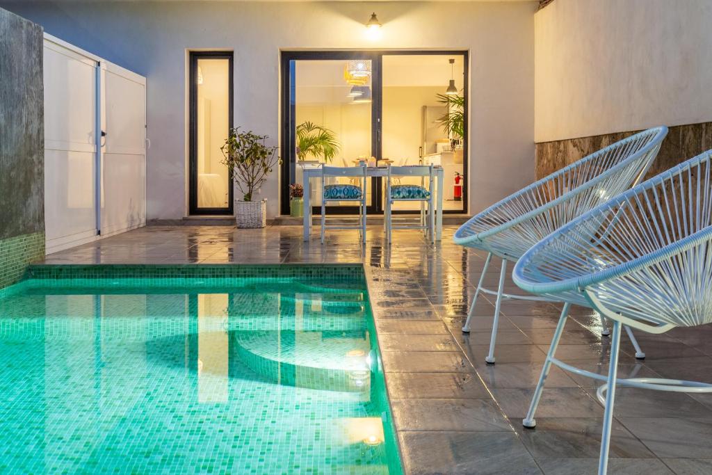einen Pool mit Stühlen und einem Tisch in einem Haus in der Unterkunft Viles Can Moreno in Ses Salines