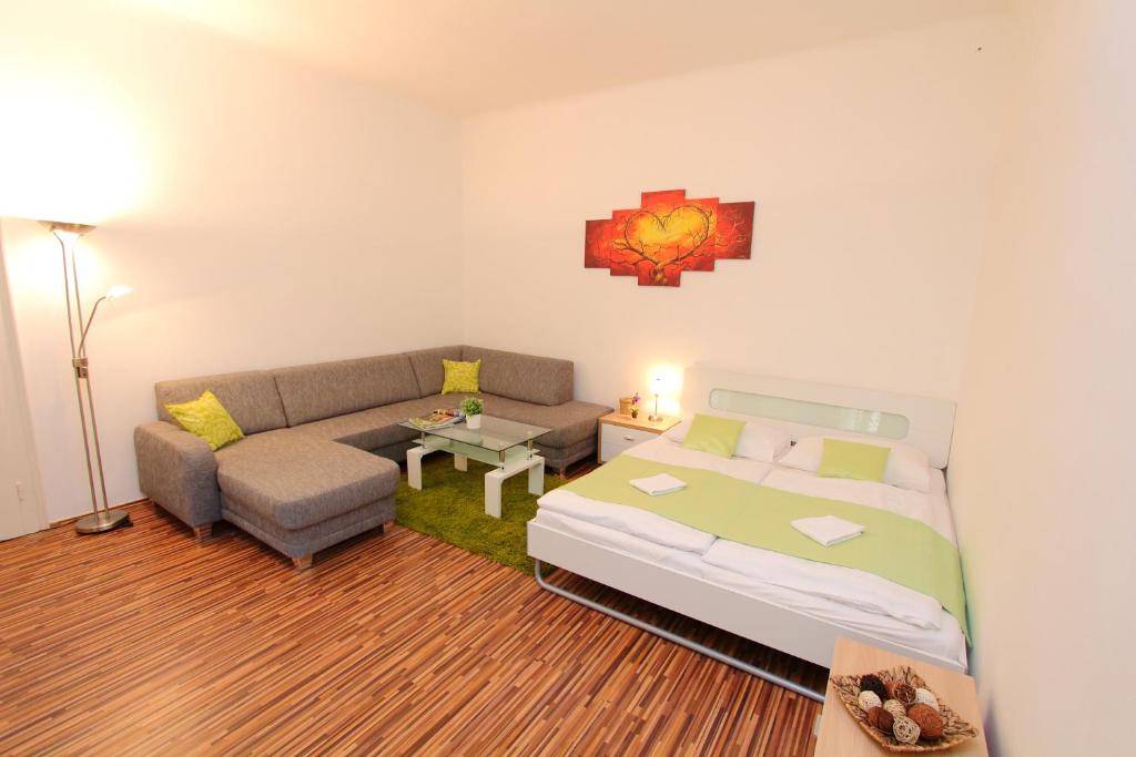 ein Schlafzimmer mit einem Bett, einem Sofa und einem Tisch in der Unterkunft Apartment Simmering in Wien