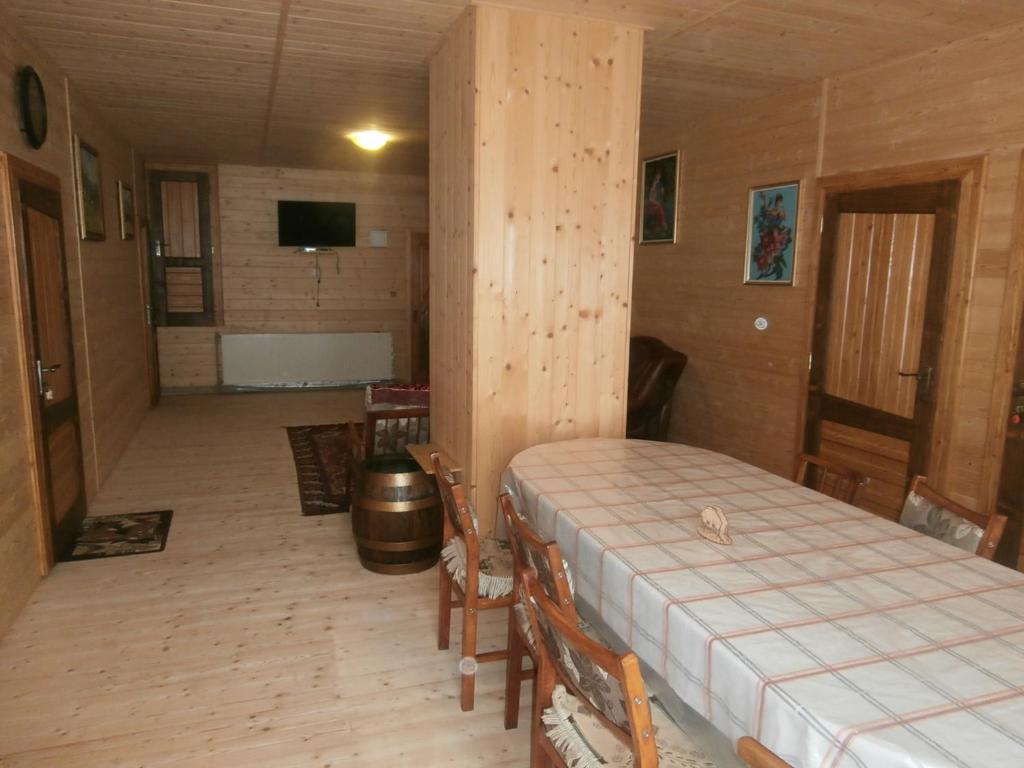 ein Schlafzimmer mit einem Bett in einem Holzzimmer in der Unterkunft Karpatskiy Domik Izki in Izky