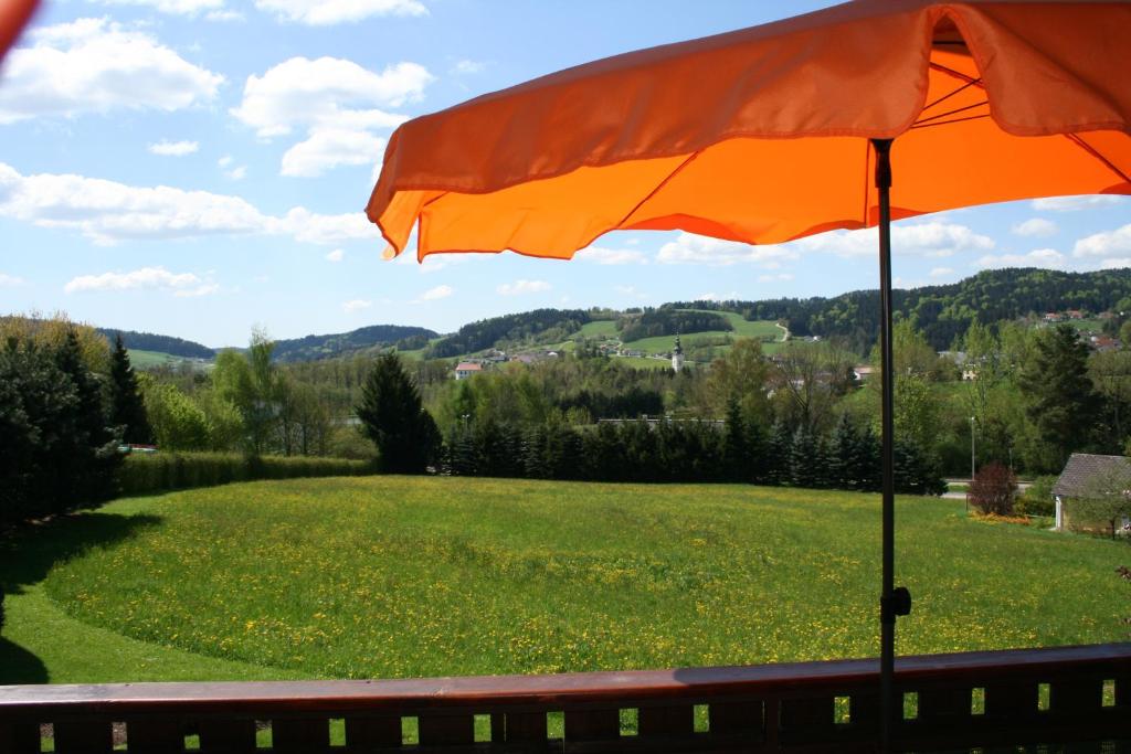 pomarańczowy parasol na zielonym polu w obiekcie Haus Christine Aigen-Schlägl - Große Mühl w mieście Aigen im Mühlkreis