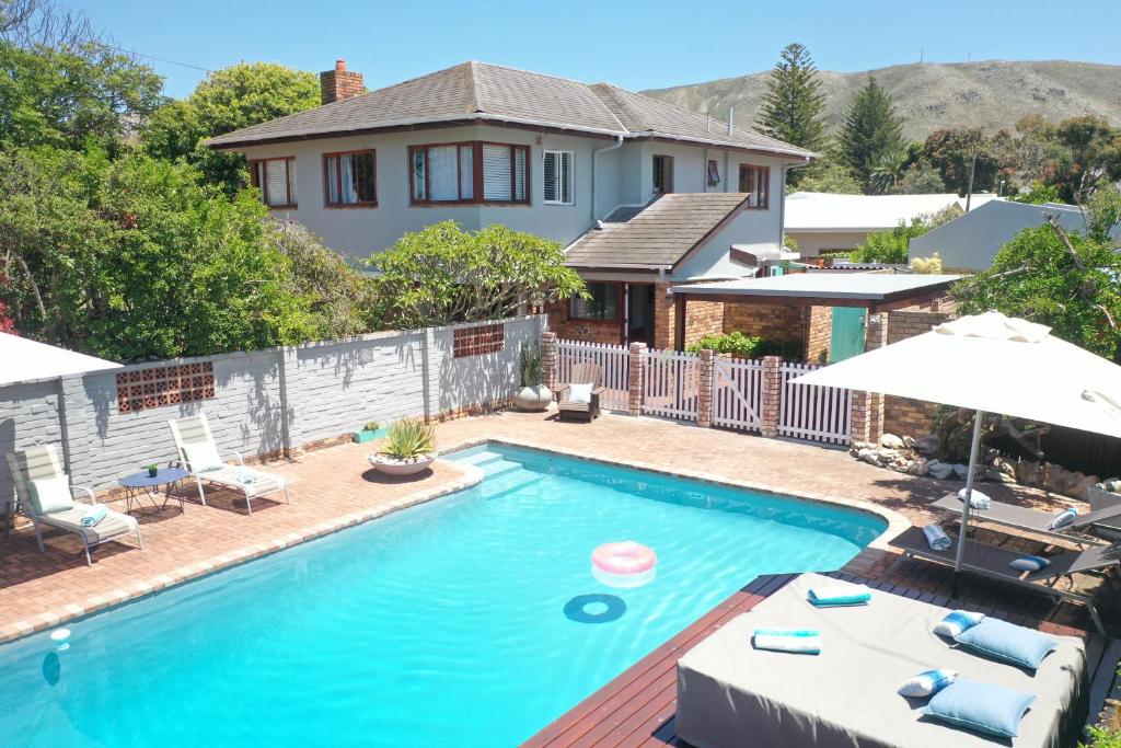 a swimming pool in front of a house at 6 Stemmet Lodge in Hermanus