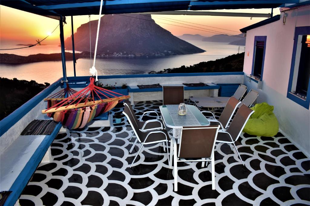 a balcony with a table and chairs and a view of the ocean at Villa Marzi Kalymnos in Kalymnos