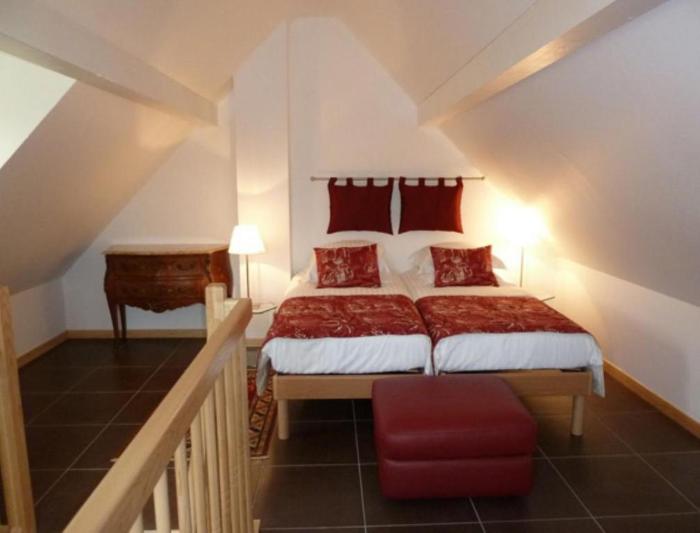 Scharrachbergheim IrmstettにあるLa Maison de Georges - Les Coquelicotsのベッドルーム1室(大型ベッド1台、赤い枕付)