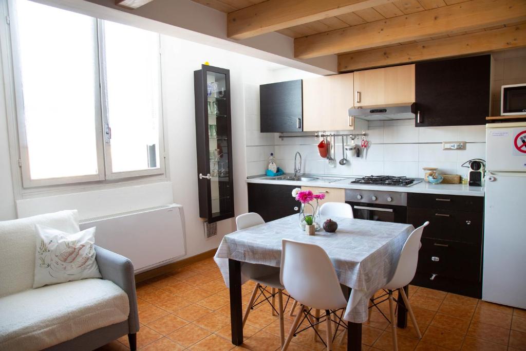 cocina con mesa y sillas y cocina con nevera en Porta Galliera Apartment en Bolonia