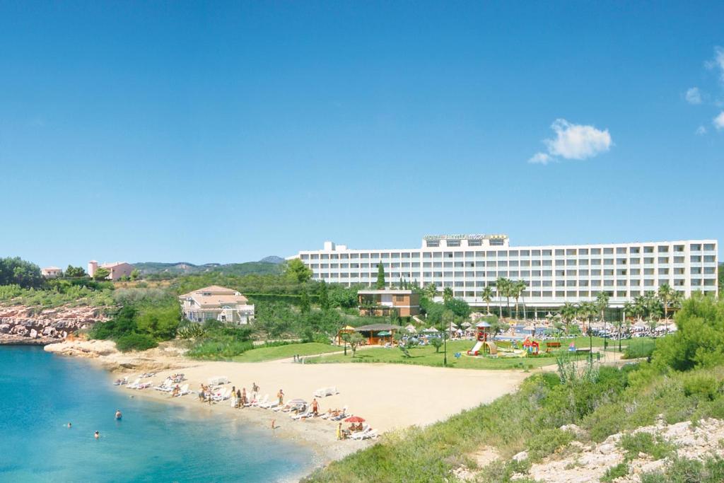 un complejo con playa y un gran edificio en RVHotels Hotel Ametlla Mar en L'Ametlla de Mar