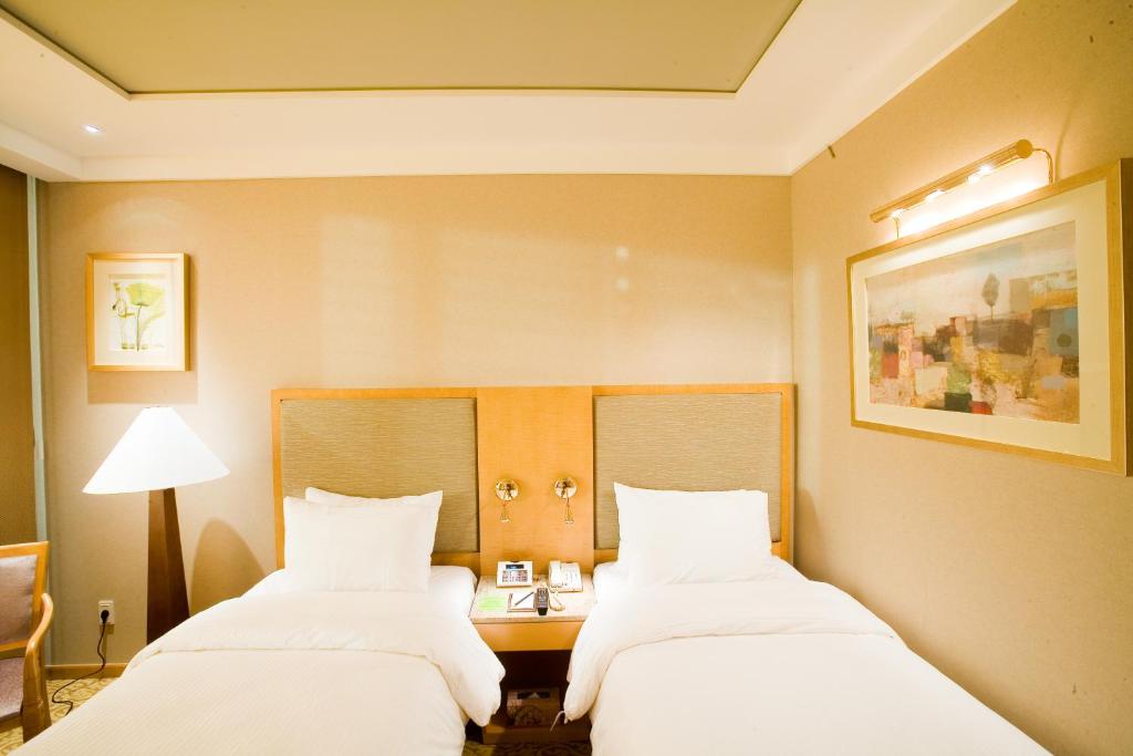 Postel nebo postele na pokoji v ubytování Daegu Grand Hotel