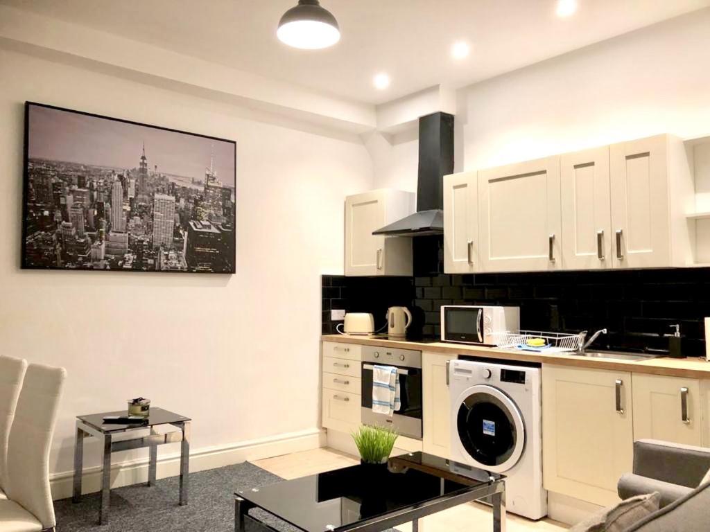uma cozinha com armários brancos e uma máquina de lavar roupa em BELMONT Apartments em Liverpool