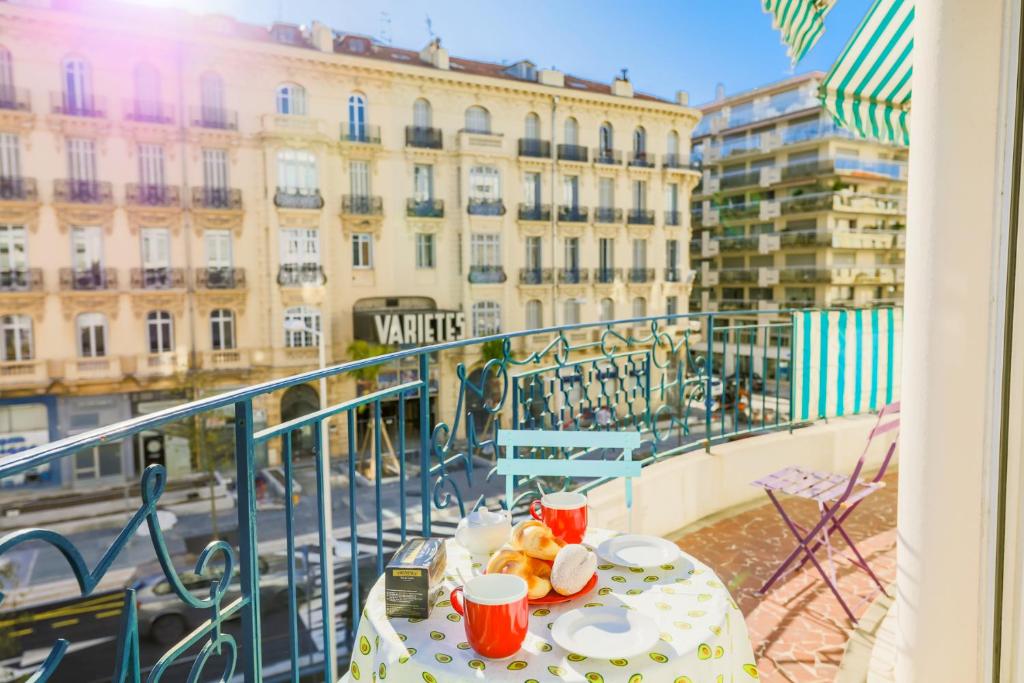 - une table sur un balcon avec vue sur un bâtiment dans l'établissement METROPOLE AP4113 Nice, by Riviera Holiday Homes, à Nice