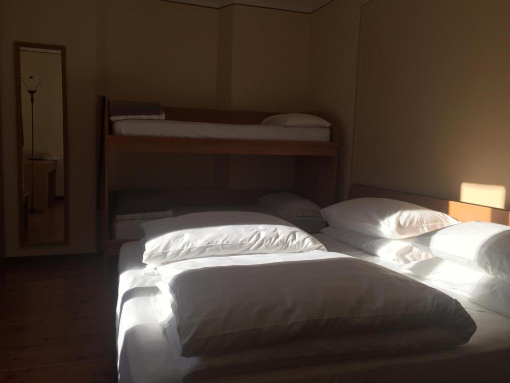 eine Gruppe von 3 Betten in einem Zimmer in der Unterkunft Hotel Adamello in Temù