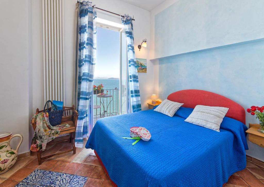 a bedroom with a blue bed and a window at Villa Lieta in Ischia