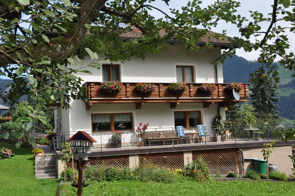 een huis met een balkon met bloemen erop bij Ferienwohnung Pezzei in Schlitters