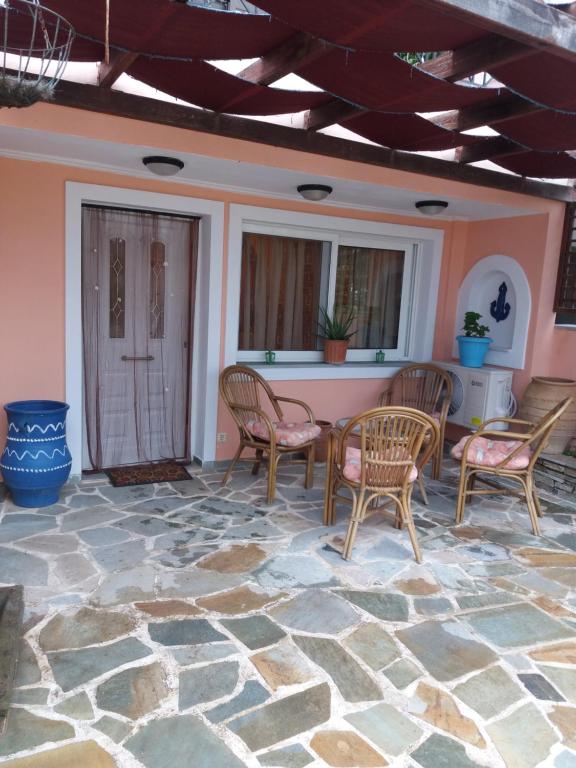 a patio with chairs and tables on a stone floor at Marmari vacation flat in Marmari