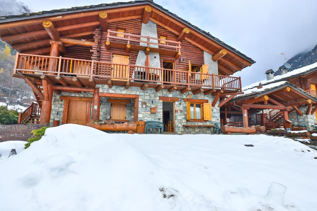 a log cabin in the snow with a balcony at Apartments La Gran Becca in Antey-Saint-André