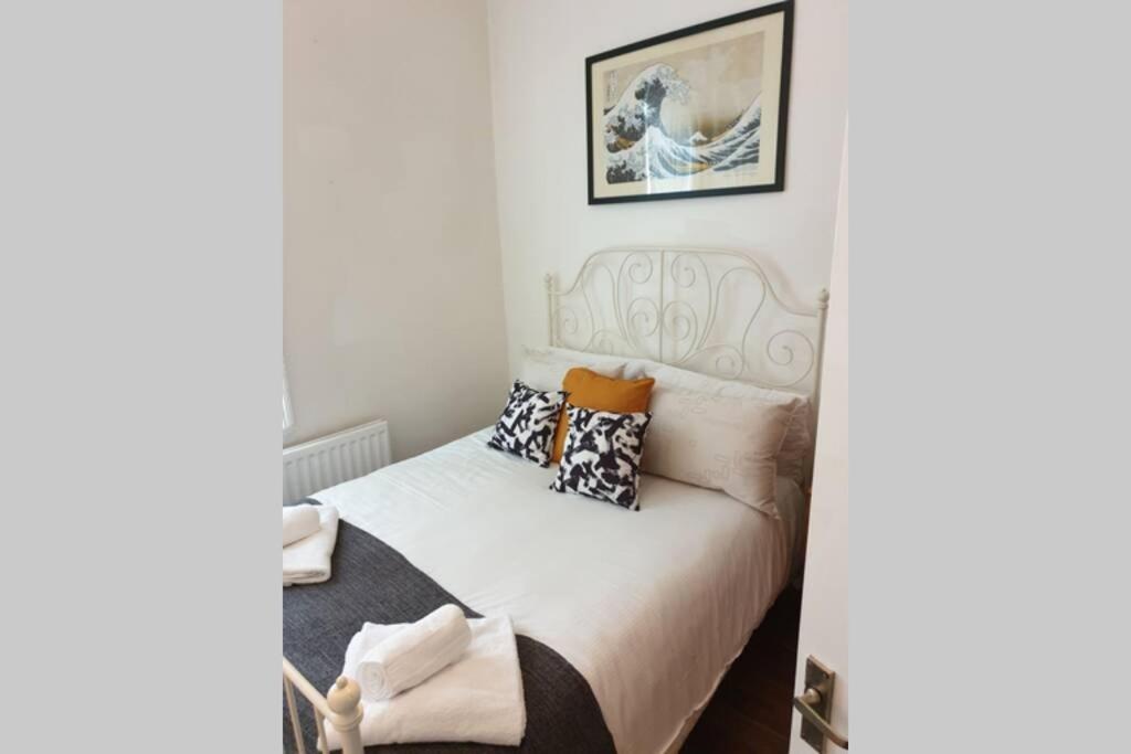 um quarto com uma cama branca com almofadas em South Shield's Hidden Gem Garnet 3 Bedroom Apartment sleeps 6 Guests em South Shields