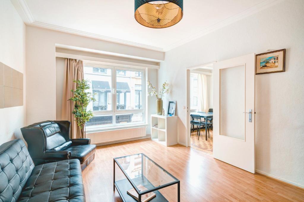 - un salon avec un canapé et une table en verre dans l'établissement Cute Cozy Apartment in Historic Center, à Anvers
