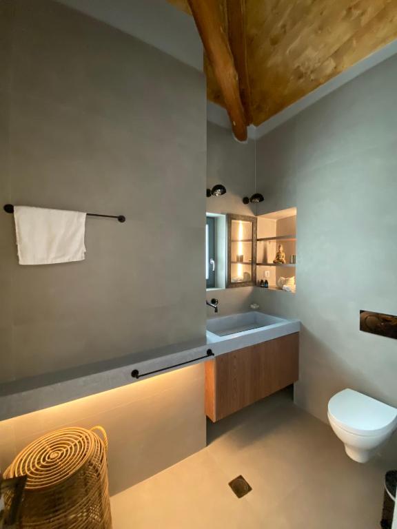 a bathroom with a toilet and a sink at CAMARA SUITES in Andros