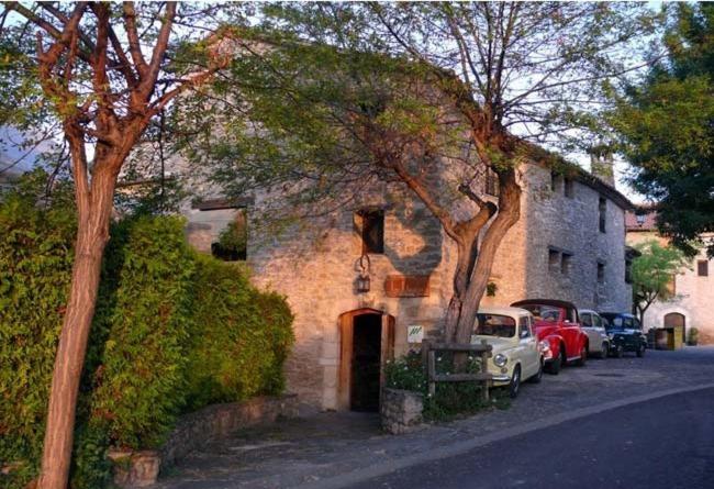 a brick building with cars parked in front of it at Casa Rural La Choca in Lecina