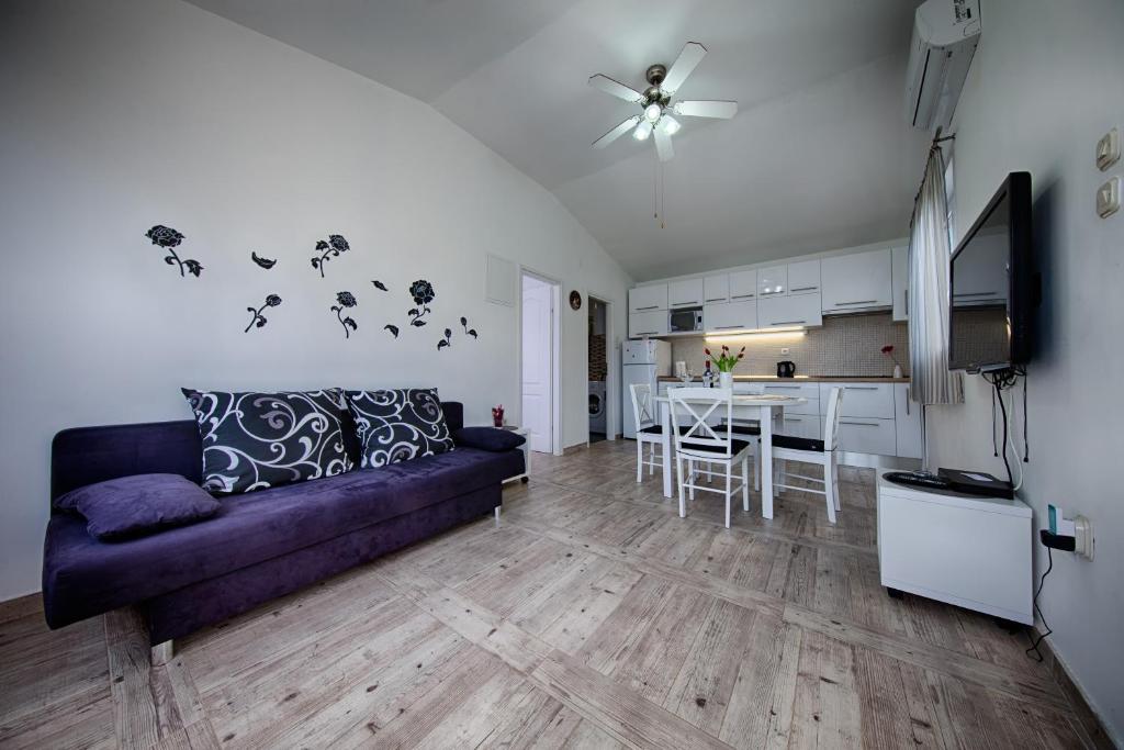 a living room with a purple couch and a kitchen at Villa Franceska in Vis