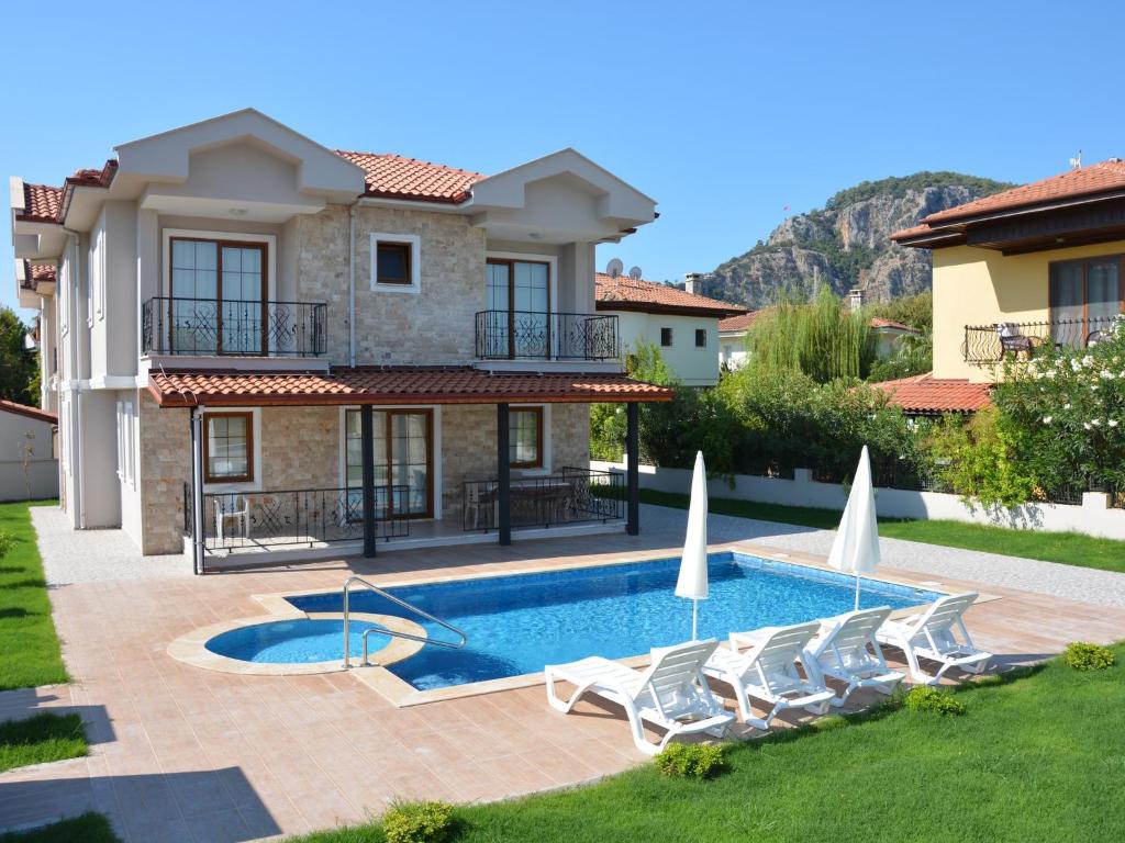 une villa avec une piscine et deux chaises longues dans l'établissement Konak Sari, à Dalyan