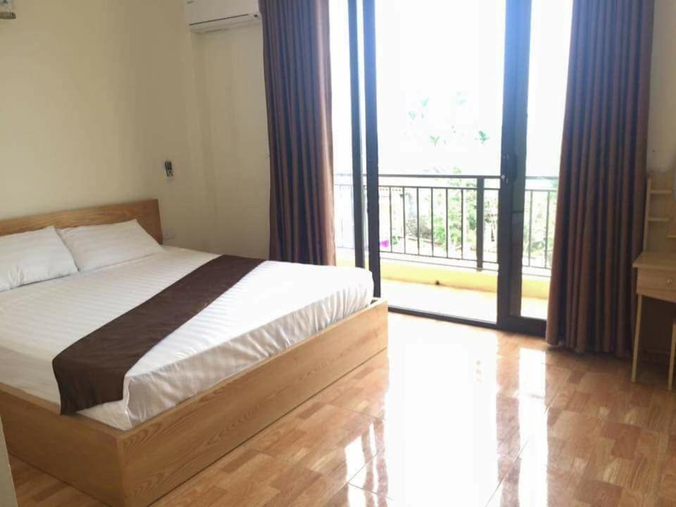 a bedroom with a bed and a balcony at AKU HOUSE Villa Ao vua in Ba Vì