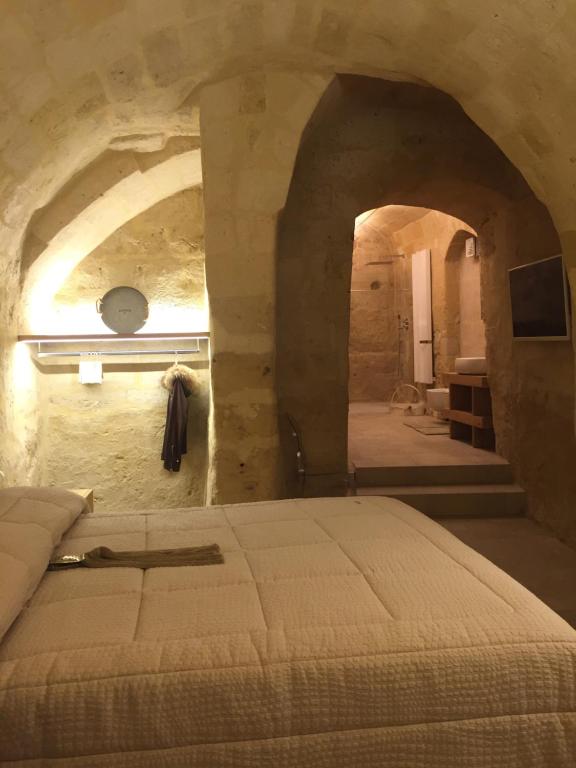 una camera con un letto in una parete in pietra di Porticina Verde Suite a Matera