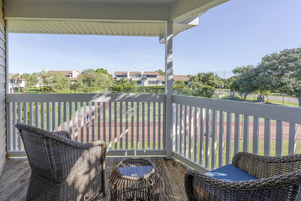 a screened porch with two chairs and a table at La Casa Del Mar 608 Star5Vacations in Dunedin