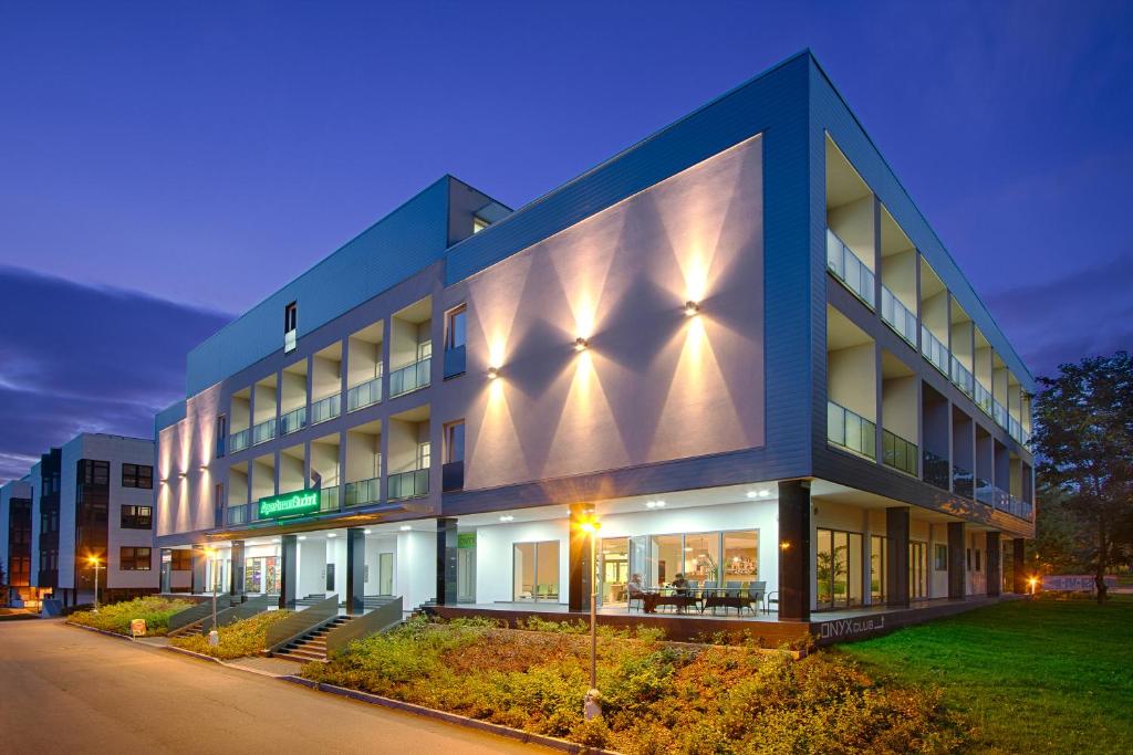 a large building with a lit up facade at night at Hotel Apartman Student in Prague