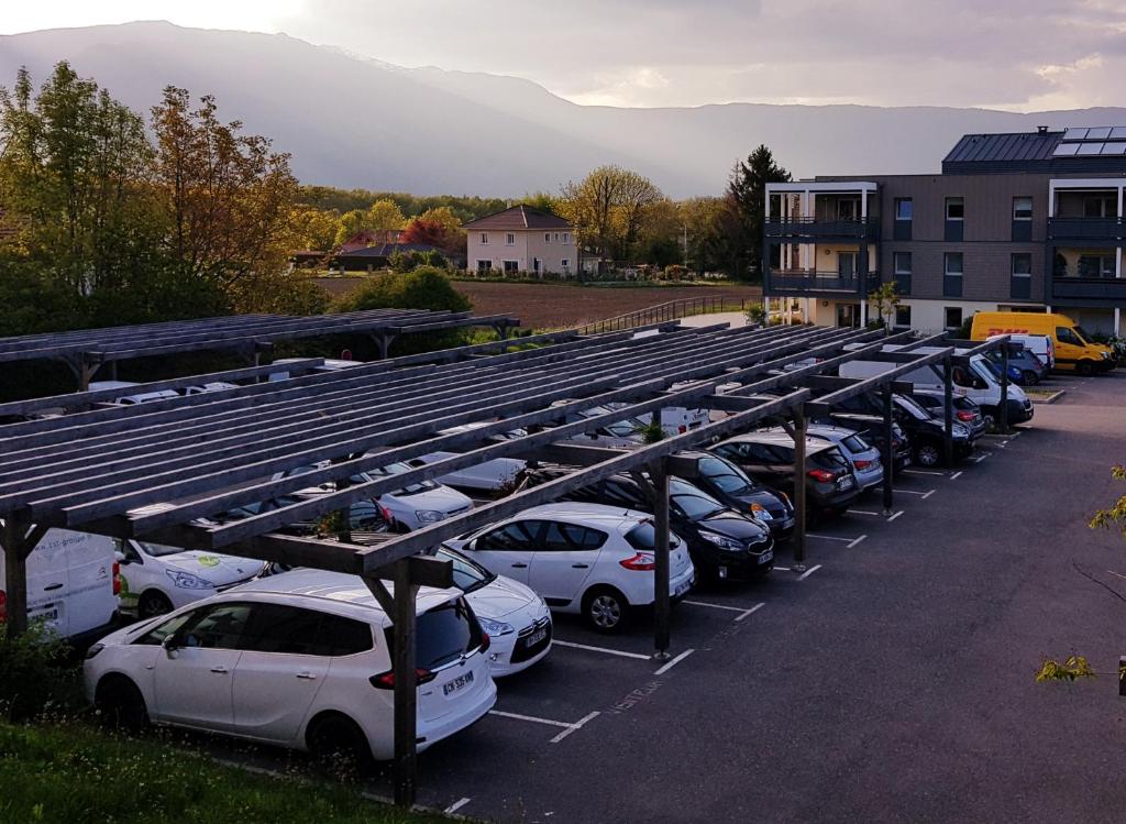 a row of cars parked in a parking lot at ViaRhona cocooning room Frei Zimmer in Valleiry
