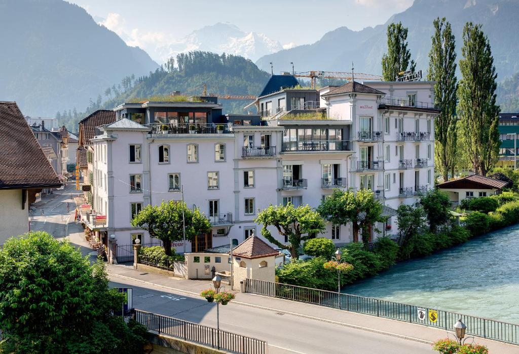 a group of white buildings next to a river at Alplodge in Interlaken