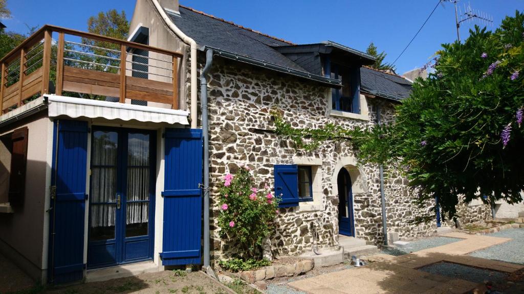 Cette maison en pierre dispose de portes bleues et d'un balcon. dans l'établissement Murmures de Loire, à Montjean-sur-Loire