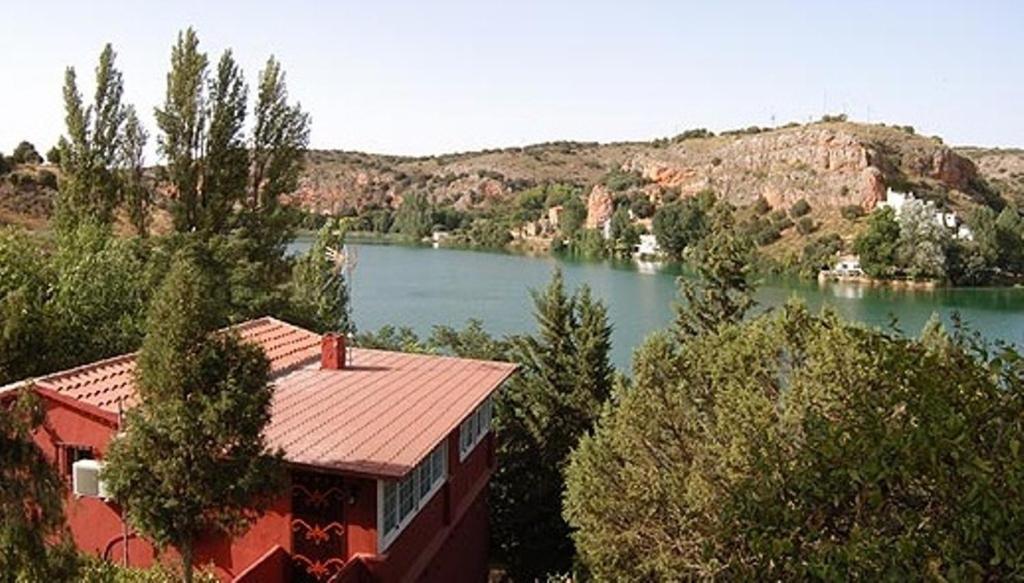 un edificio con vistas a un río y a una casa en La Buena Siesta, en Ruidera