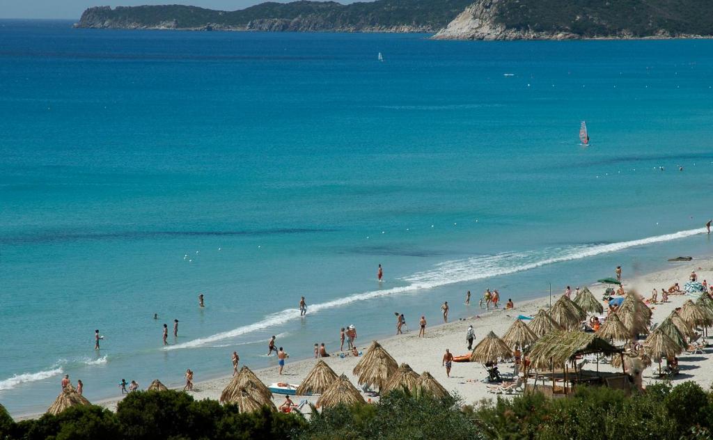 a group of people on a beach in the water at Residence Fenicia in Villasimius
